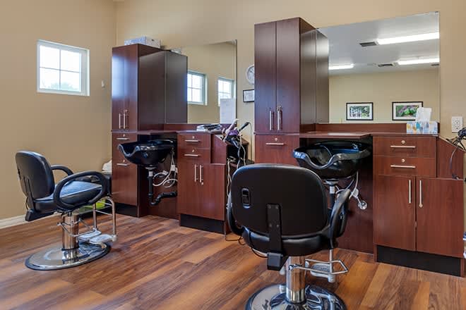 A modern hair salon with sleek barber chairs and wood flooring.