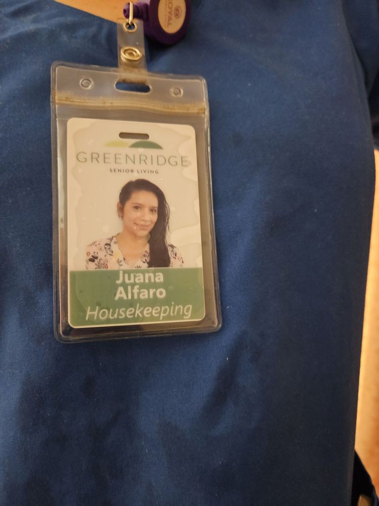 An employee ID badge with a photo and name on a uniform.