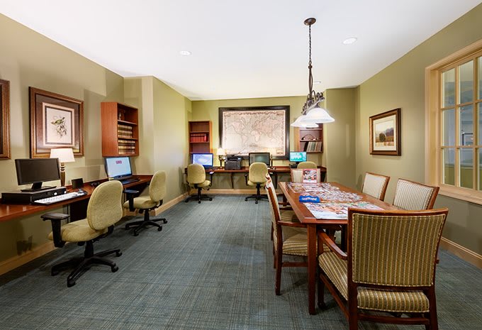 A well-organized office space featuring computers, desks, and chairs arranged for work and meetings.