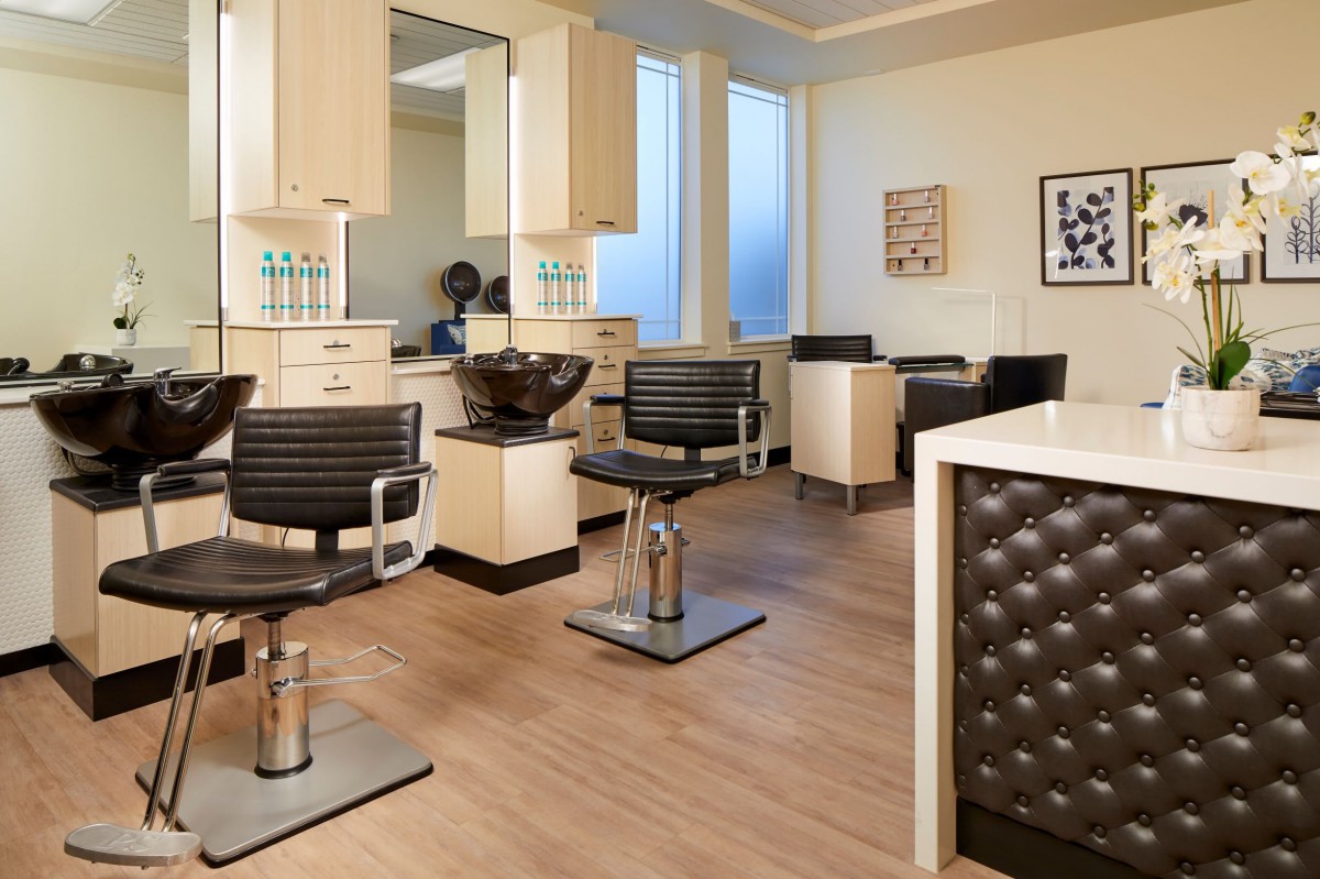 An elegant and modern hair salon with chairs, mirrors, and workstations.