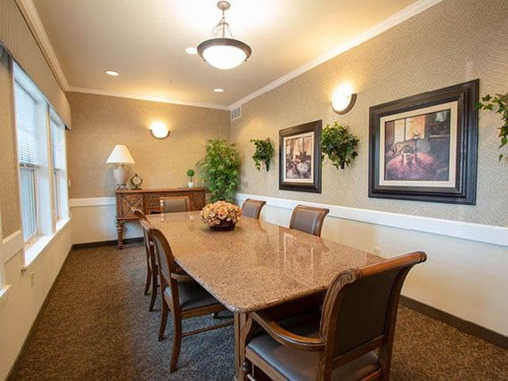 Elegant dining room with a polished wooden table and artwork on the walls.