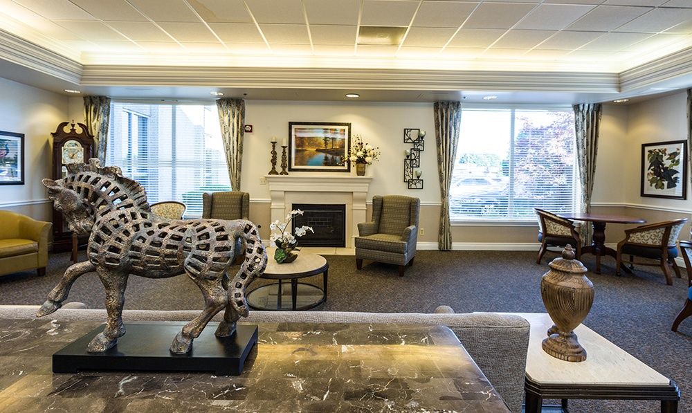 A beautifully decorated living room featuring a central fireplace, stylish furniture, and a striking sculpture.