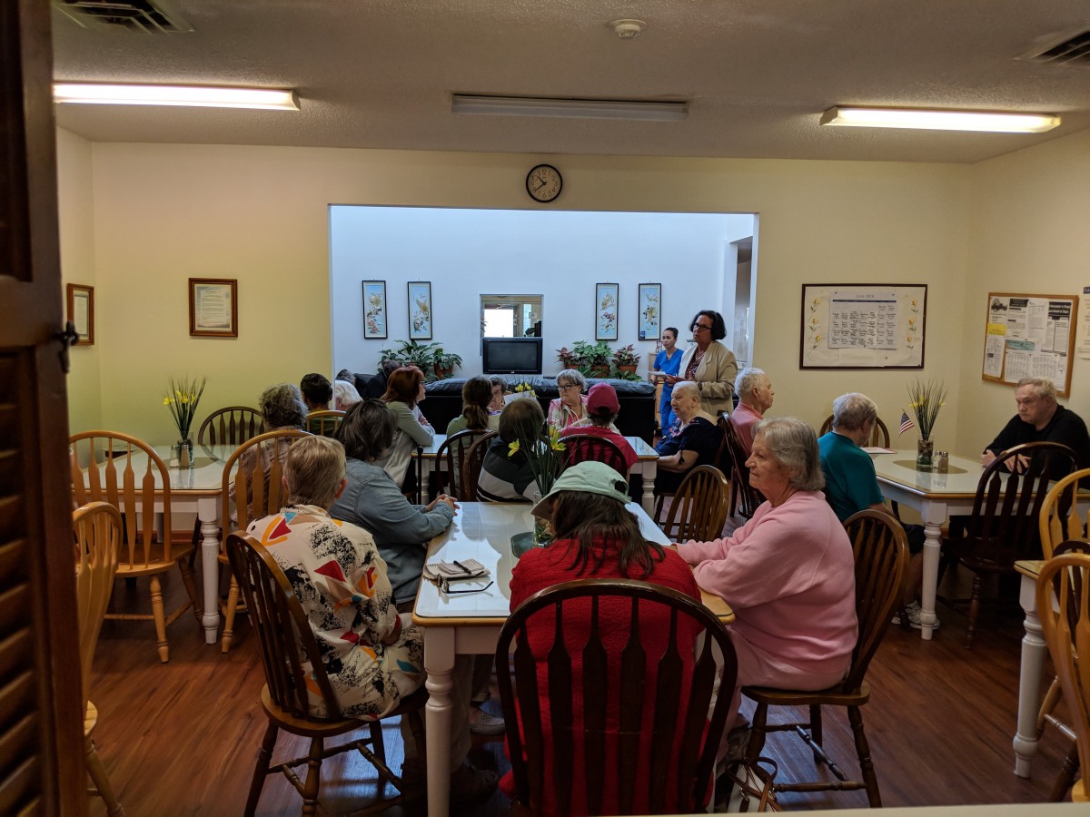 A group of seniors attending a meeting in a community room.