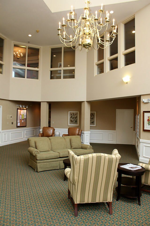 A spacious lobby with comfortable seating and a chandelier.