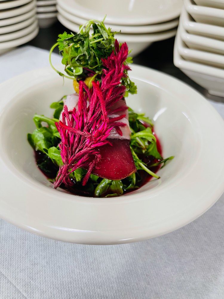 A beautifully plated gourmet salad with vibrant beets and fresh greens.