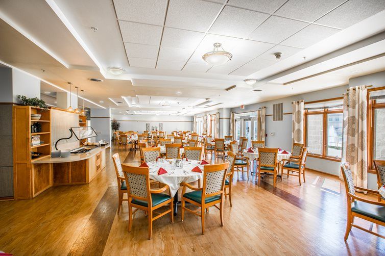 A spacious and well-lit dining area with neatly arranged tables and chairs, featuring modern interior design.