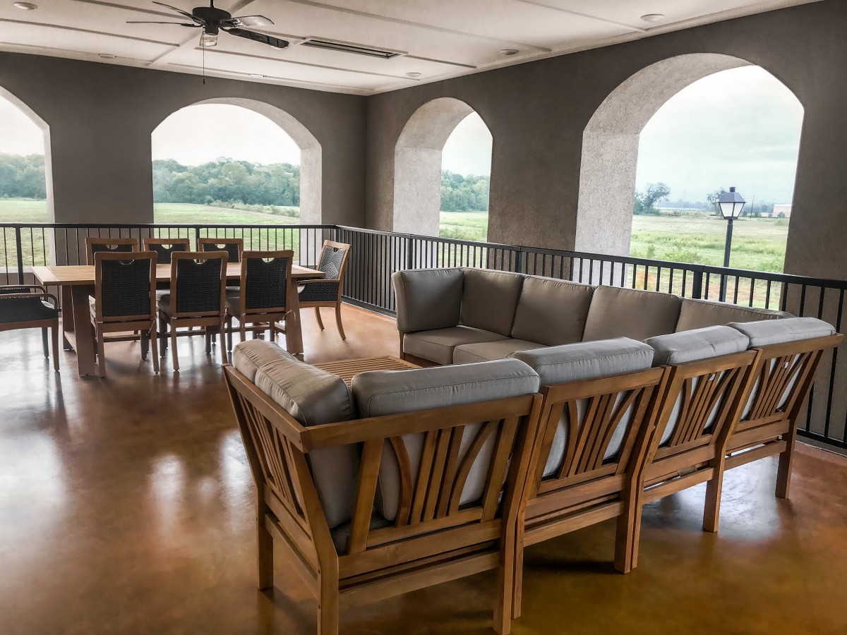 An elegant balcony with cozy wooden seating and a scenic view.