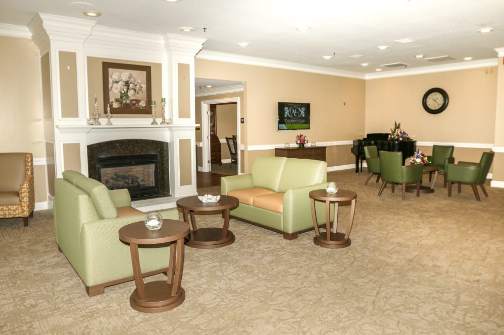 A cozy living room with comfortable seating, a fireplace, and a piano.