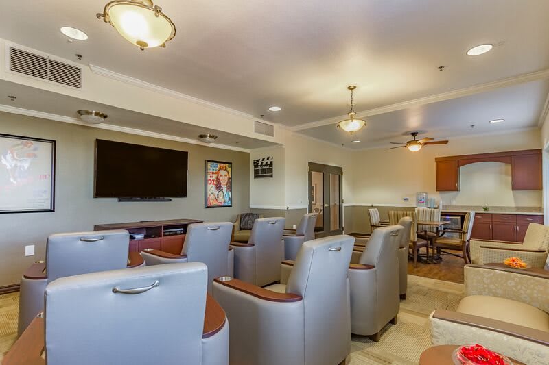 A comfortable lounge area featuring plush chairs, a large television, and modern decor.