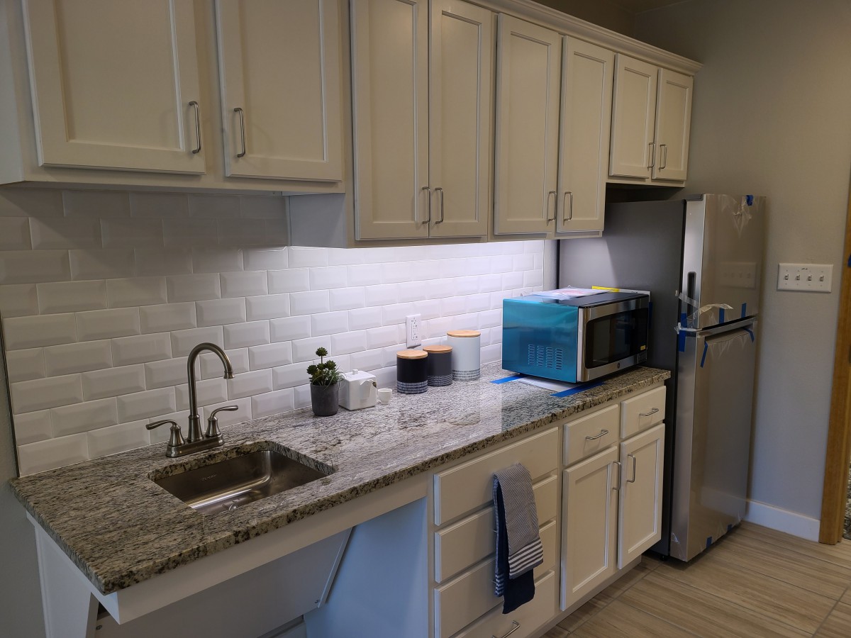 A modern kitchen with white cabinets and a sleek countertop.