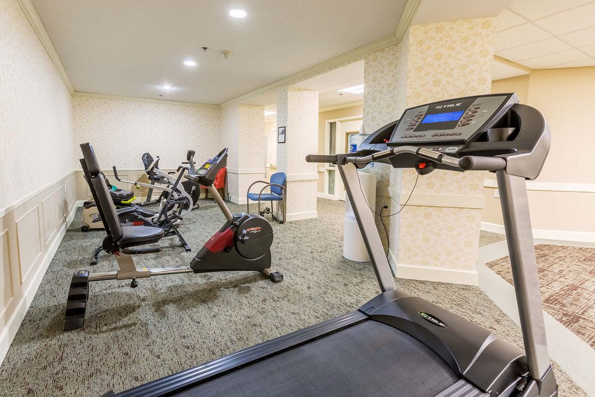A well-equipped gym with treadmills, stationary bikes, and other exercise machines.