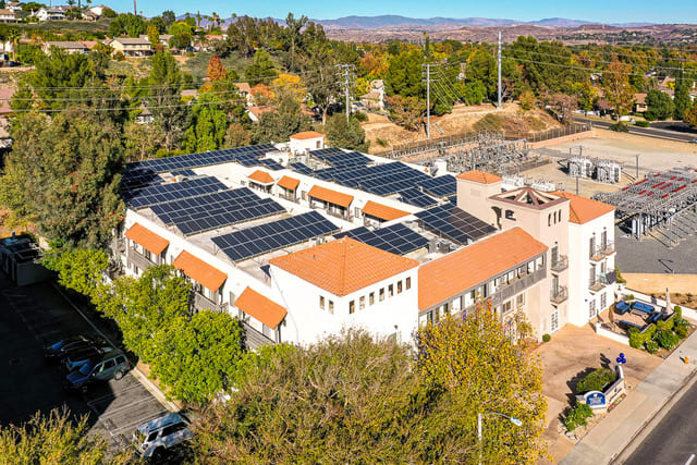 An aerial view of a building with solar panels installed on the rooftop, showcasing sustainable energy efforts.