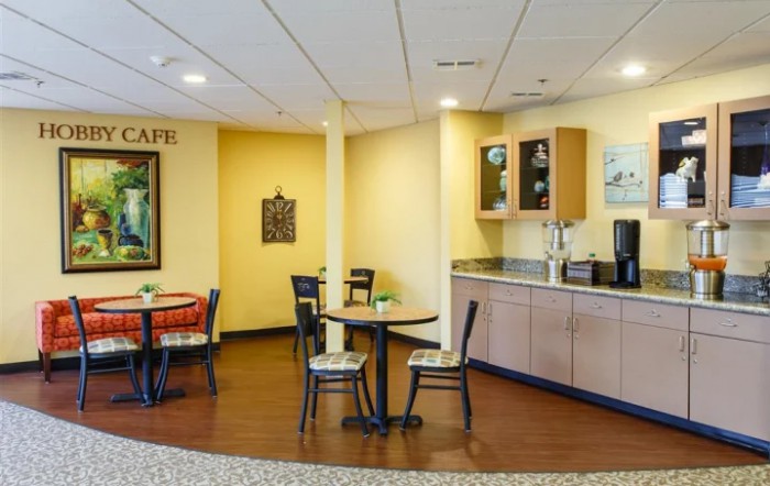 A cozy cafe interior with tables, chairs, and a coffee station.