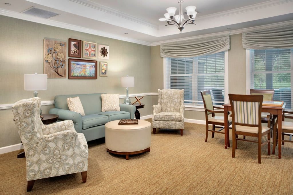 A cozy living room with a sofa, armchairs, a coffee table, and a small dining area.