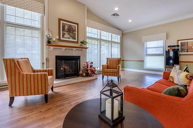 A cozy living room with a fireplace, modern decor, and large windows.