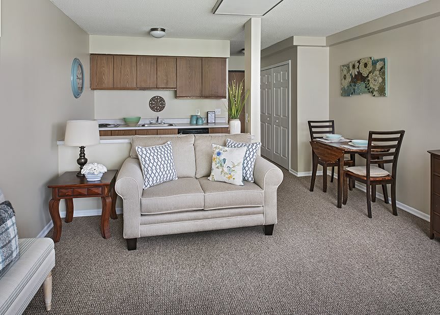 A cozy living room with a sofa, adjacent to an open kitchen and dining area.
