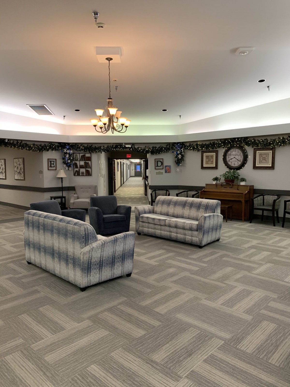 A cozy lobby seating area with couches and armchairs under a chandelier.