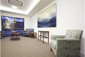 A cozy waiting room with comfortable seating and calming artwork on the wall.