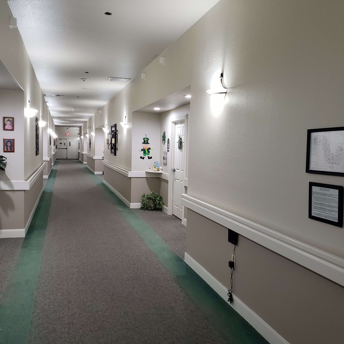 A well-lit indoor hallway with multiple doors and wall decorations.