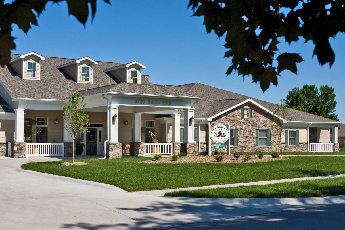A suburban residential building with a well-maintained lawn and driveway.