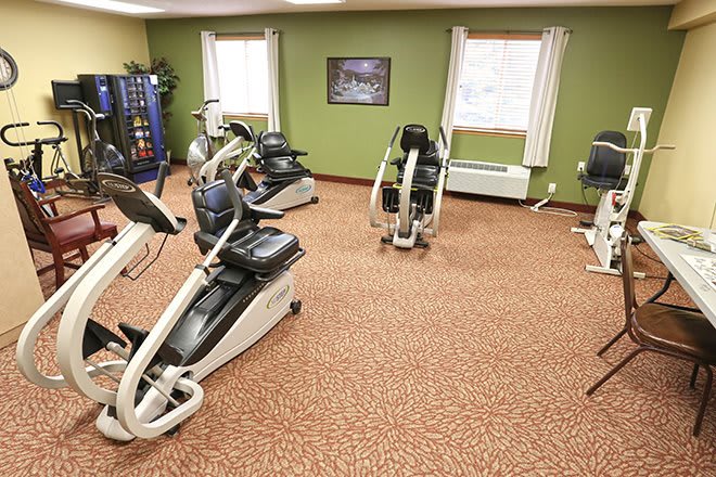 A fitness room featuring various cardio exercise machines.