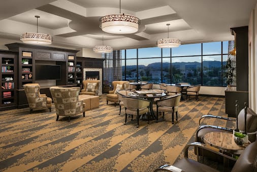 A cozy lounge area with comfortable seating and large windows offering a scenic view.
