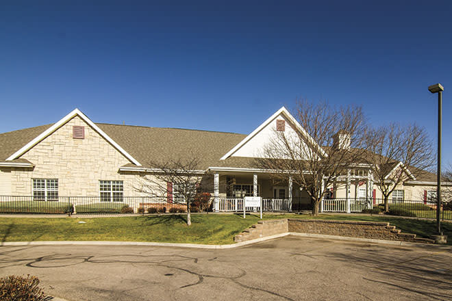 A suburban residential building with a light-colored exterior under a clear blue sky.