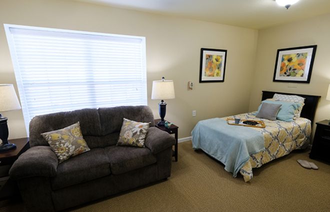 A cozy room featuring a sofa, single bed, and warm lighting.