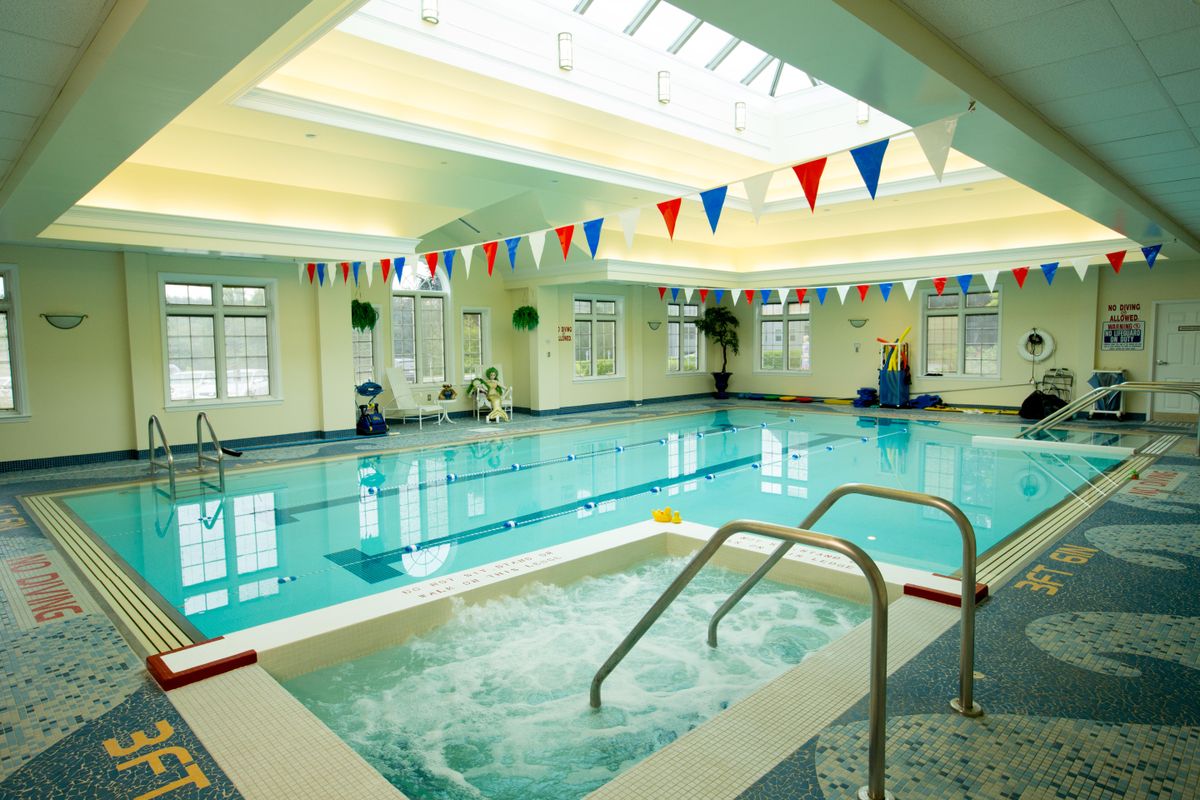 An indoor swimming and jacuzzi area with bunting flags at a leisure center.