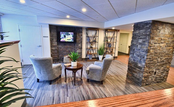 A modern lobby with comfortable seating, a stone accent wall, and decorative plants.