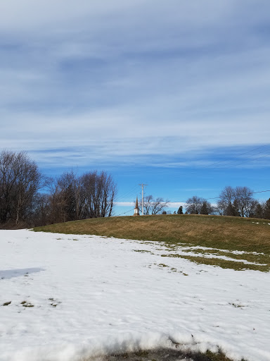 A serene winter landscape with patches of snow and a clear blue sky.