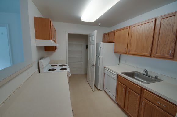 A small kitchen with wooden cabinets and basic appliances.