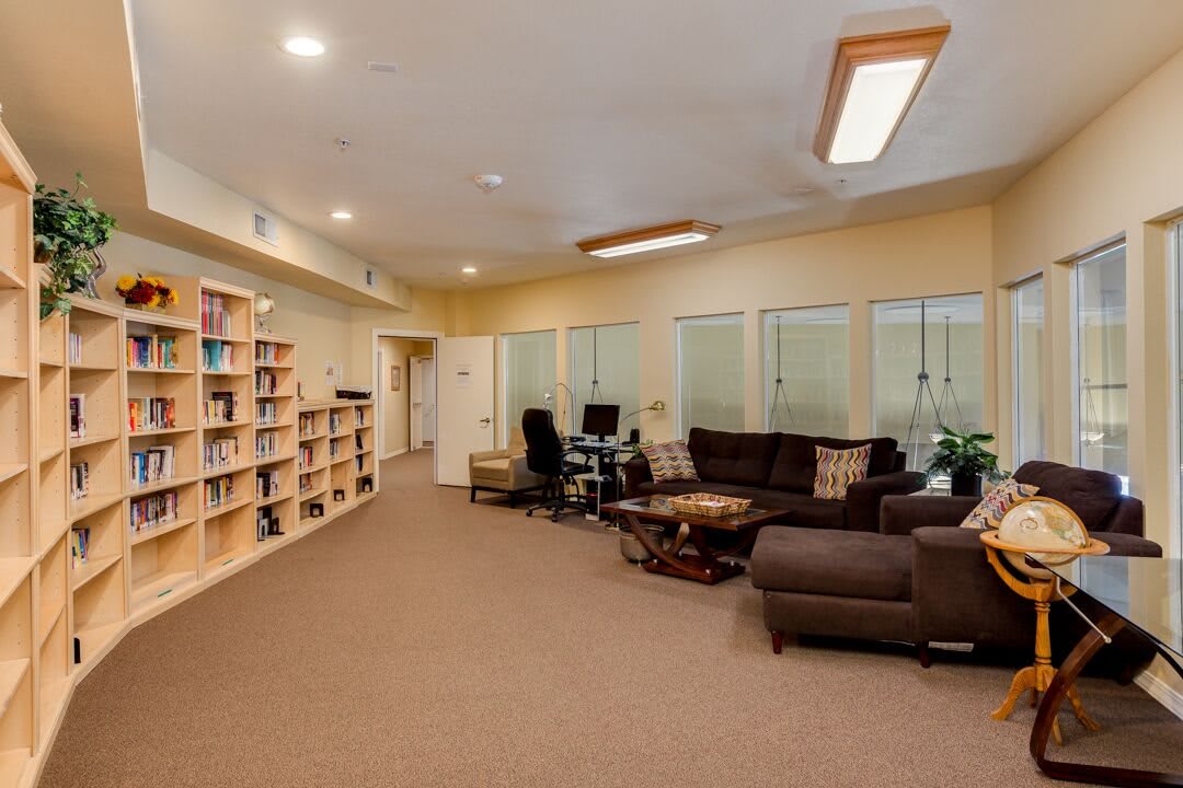 A spacious office interior with bookshelves, desks, and comfortable seating.