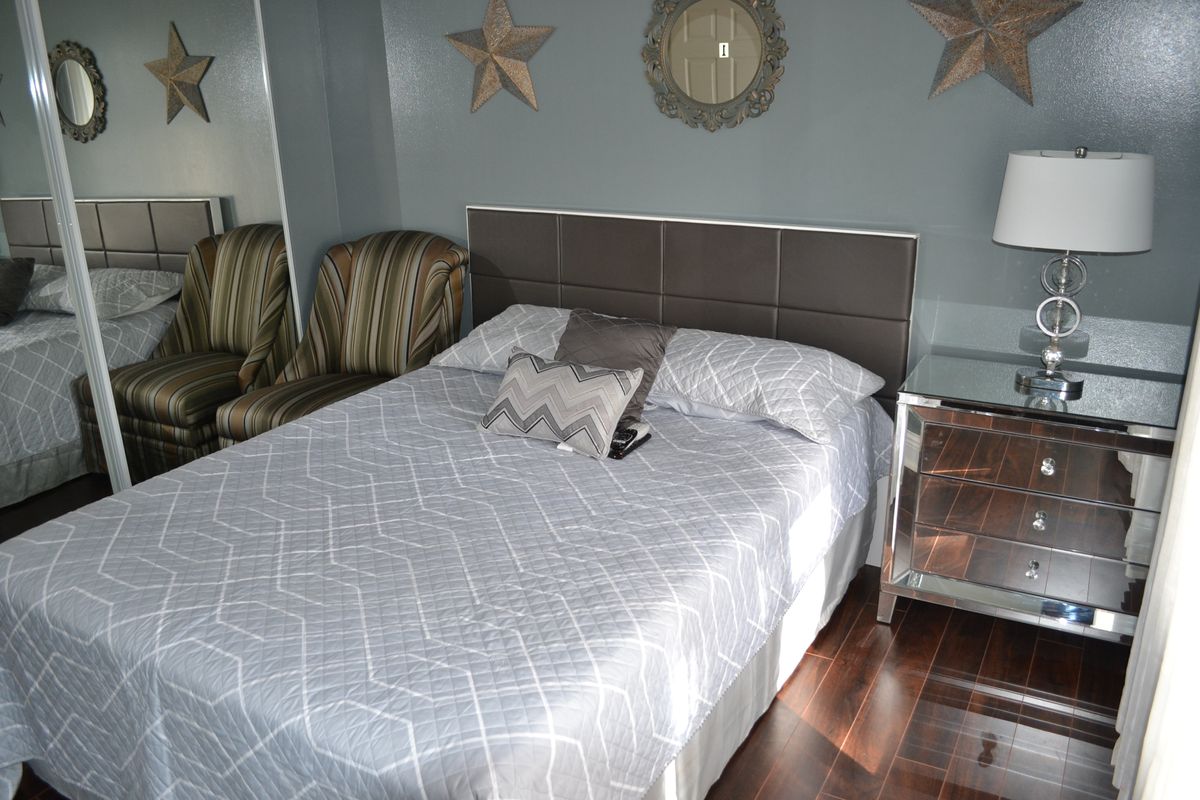 A cozy bedroom with modern decor and a comfortable bed.