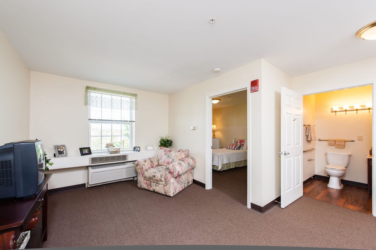 A cozy living space with a sofa and a view into an adjacent bedroom.