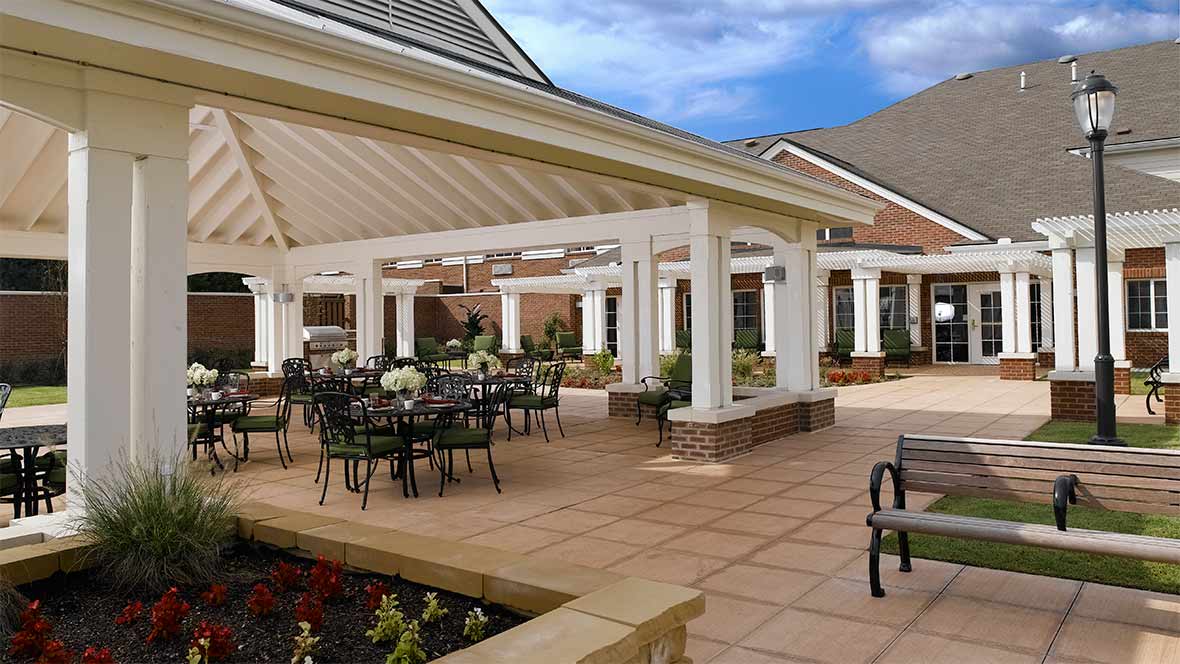 A spacious outdoor patio area with a pergola and seating arrangements.