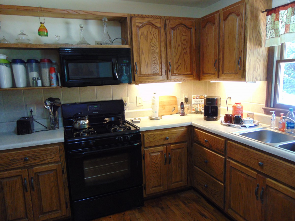 A cozy kitchen with wooden cabinets and various appliances.