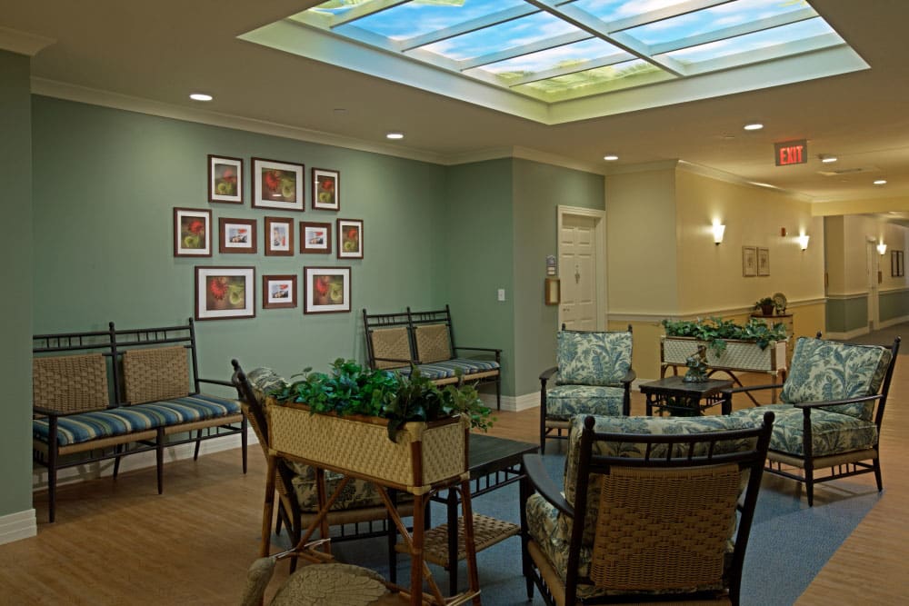 A cozy lounge area with seating, artwork on the walls, and a decorative ceiling light.