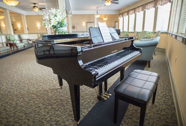 A grand piano with sheet music in a well-lit music room.