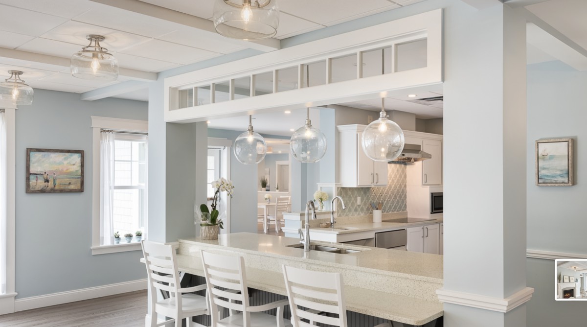 A modern kitchen with a spacious layout, featuring a large countertop and stylish pendant lighting.