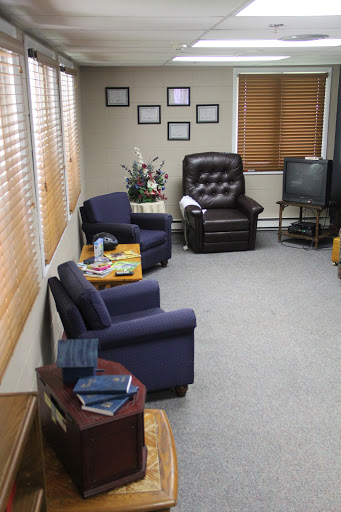 A cozy waiting room featuring comfortable chairs and a small coffee table.
