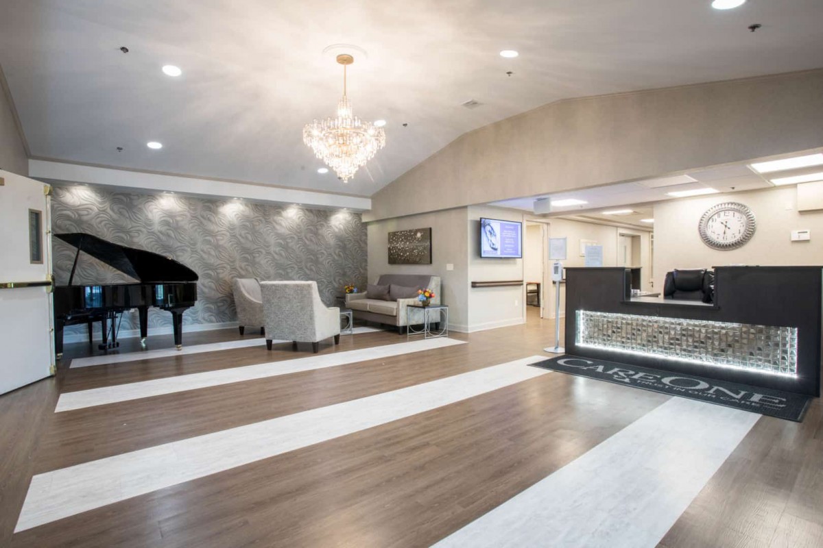 A modern lobby with elegant furnishings, featuring a grand piano and chandelier.