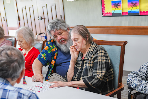A group of senior citizens engaged in a game at a community center, showing interaction and camaraderie.