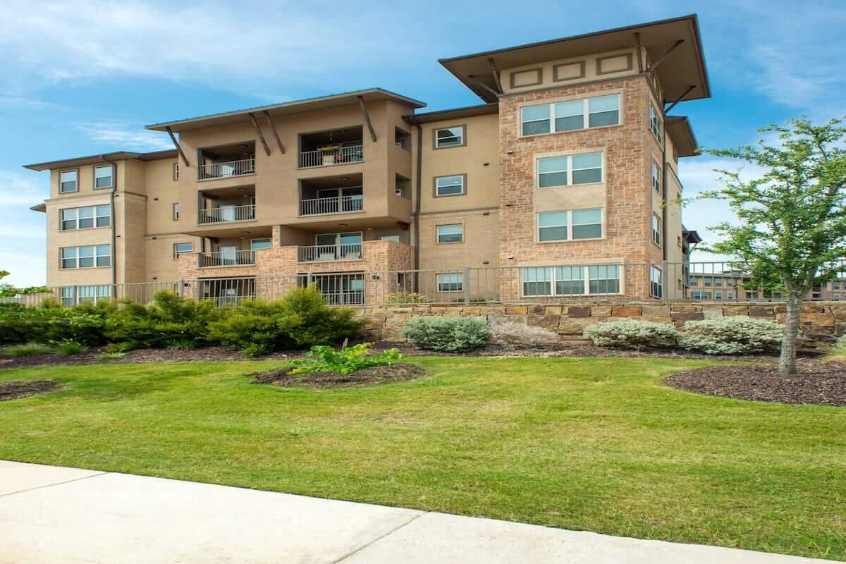 A modern residential apartment building with landscaped surroundings.