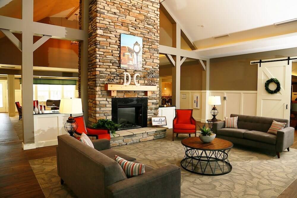 A cozy living room with a rustic stone fireplace and comfortable seating.