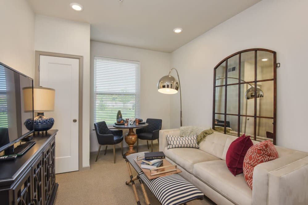 A cozy living room with a comfortable sofa, a large mirror, and stylish decor elements.