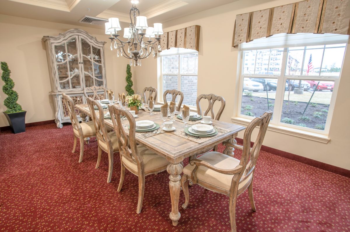 An elegant dining room with a chandelier and beautifully set table.
