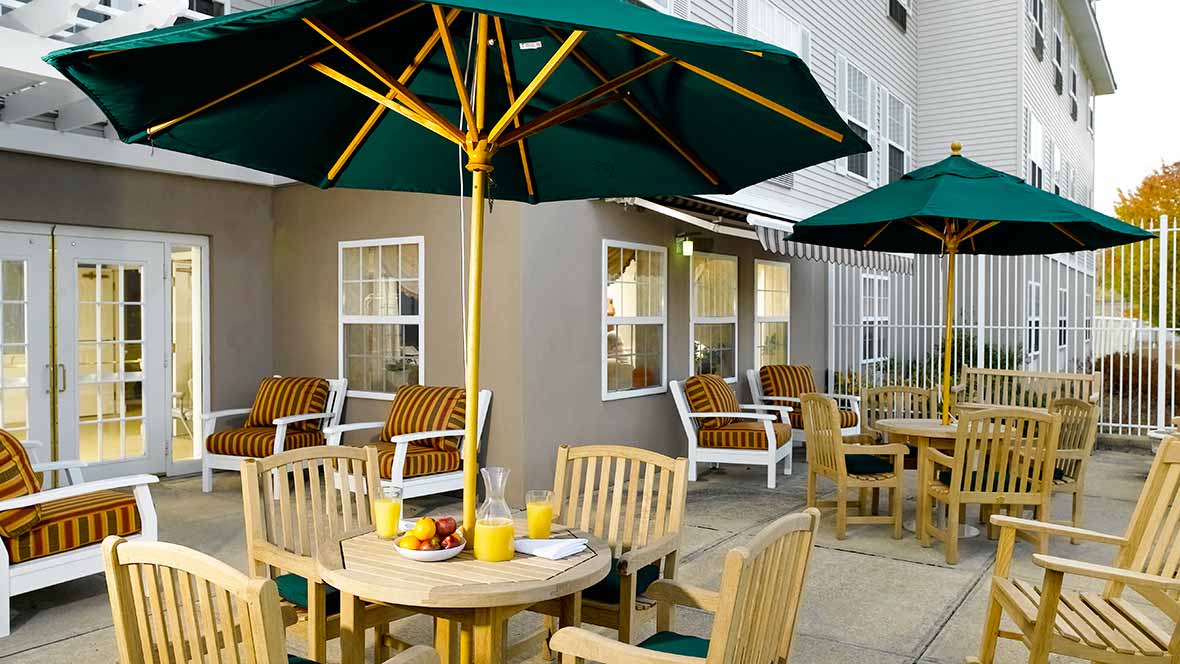 Outdoor patio area with tables, chairs, and umbrellas.