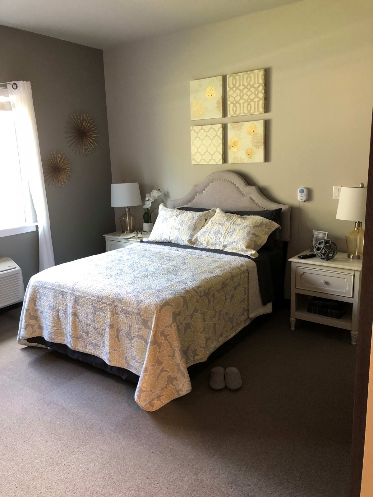 A cozy bedroom with a neatly made bed, nightstands, and decorative elements.