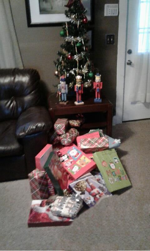 A living room decorated for Christmas with a small tree and an assortment of wrapped gifts.